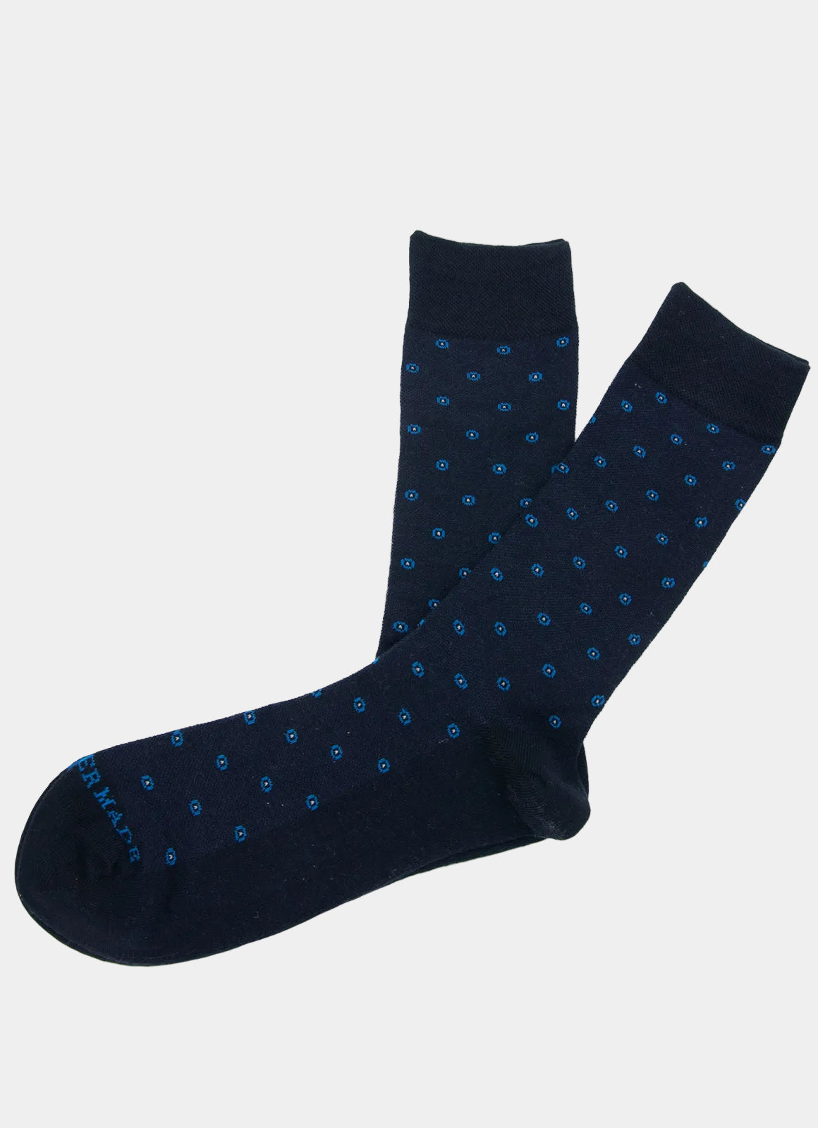 A pair of Navy/Blue Circle Dot Socks, featuring small blue polka dots on dark navy cotton, laid flat on a white background. Made in Turkey and designed to comfortably fit sizes 8-12.