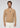 A man stands facing forward against a plain light gray background, wearing the Milano 1/4 Zip Merino Wool Sweater in tan over a cream shirt and cream pants.