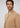 A man with wavy brown hair and a beard models the Milano 1/4 Zip Merino Wool Sweater in beige, layered over a white shirt, against a plain light gray background.