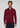A man stands facing forward, wearing the Milano 1/4 Zip Merino Wool Sweater in maroon over a collared shirt and paired with dark pants. The plain light gray background highlights the refined simplicity of this luxury men’s knitwear.