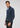 A man wearing the Milano 1/4 Zip Merino Wool Sweater, styled over a light blue collared shirt and dark jeans, stands against a plain light gray background, looking into the camera.