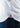 Close-up of a person in blue jeans and a white Bergamo Stretch Button Down, featuring a small patch with a red no-crab symbol at the shirt’s split hem.