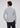 A man with curly hair, seen from behind, is wearing the Bethel Button Down—a subtle blue, long-sleeve shirt from Hammer Made crafted from premium cotton—paired with dark pants.
