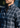 A man with a short beard wears the Como Italian Flannel shirt, featuring a navy grey plaid pattern and crafted from premium Canclini cotton, outdoors. His head is slightly turned, and only his torso and lower face are visible.