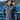 Wearing the Como Italian Flannel, a man in sunglasses stands by a waterfront railing, with hills, water, and buildings visible in the bright background.