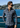 Wearing the Como Italian Flannel, a man in sunglasses stands by a waterfront railing, with hills, water, and buildings visible in the bright background.