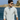 A man wearing the Gale 1/4 Zip in light gray and sunglasses stands by the water, cliffs and blue sky behind him on a sunny day—a perfect setting for lightweight layering.