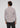 A man with curly hair, viewed from behind, wears the Lowry Button Down—crafted from premium European cotton and featuring a subtle geometric pattern—paired with dark jeans as he stands against a plain light background.
