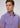 A man wearing the Lyon Reversible Polo, a purple patterned essential for any men’s everyday wardrobe, looks slightly to his left against a plain gray background. This stylish shirt also features UPF 50+ protection for added comfort and confidence throughout the day.