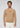 A man stands facing forward against a plain light gray background, wearing the Milano 1/4 Zip Merino Wool Sweater in tan over a cream shirt and cream pants.