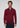 A man stands facing forward, wearing the Milano 1/4 Zip Merino Wool Sweater in maroon over a collared shirt and paired with dark pants. The plain light gray background highlights the refined simplicity of this luxury men’s knitwear.