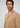 A man with wavy brown hair and a beard models the Milano 1/4 Zip Merino Wool Sweater in beige, layered over a white shirt, against a plain light gray background.