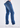 Person wearing comfortable jeans made from Sanded Tapered Stretch Denim and white sneakers, standing on a white background, shown from the waist down and turned slightly to the side.